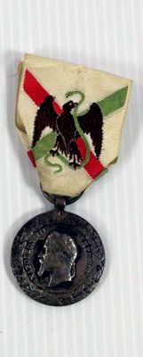 une petite médaille sur laquelle est représenté un aigle, sur un fond blanc