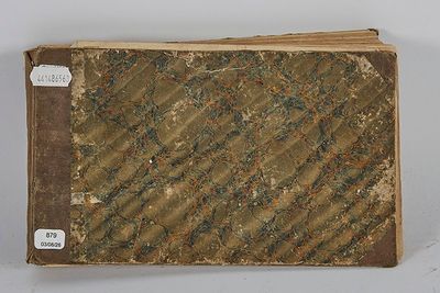 un vieux livre à la couverture marron posé sur une table