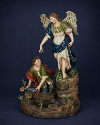 an image of a statue of an angel and a man kneeling on a rock