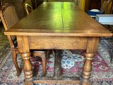 a wooden table and chairs in the middle of a room