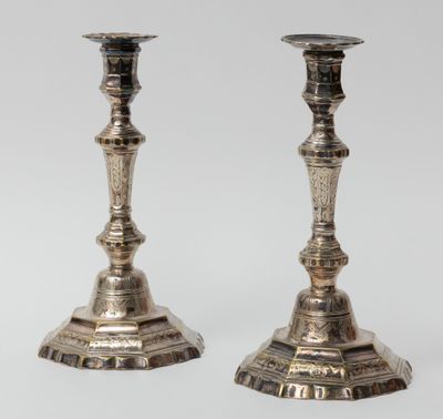 pair of antique silver candlesticks on a white background