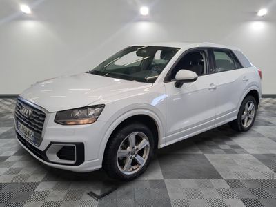 un SUV Audi blanc garé dans un garage au sol carrelé