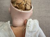a doll head with a nut in it ' s head