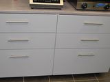 un micro-ondes posé sur une commode, à côté d'un four grille-pain