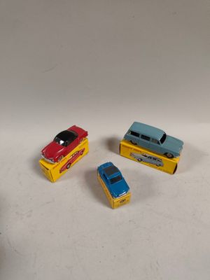 trois petites voitures posées sur une surface blanche