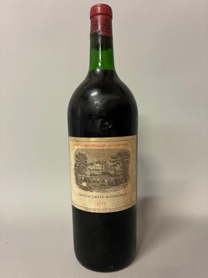 une vieille bouteille de vin posée sur une table blanche