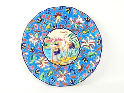 blue plate with a picture of a crane and flowers on it