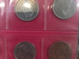 four different types of coins are displayed in a display case