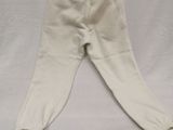 a white pant laying on a bed with a white sheet