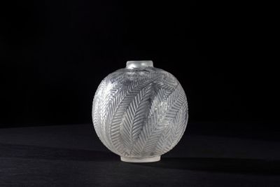a glass vase sitting on a table with a black background
