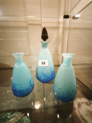 three blue vases on display in a glass case