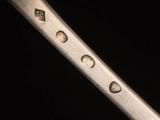 a close up of a knife with a lot of holes on it
