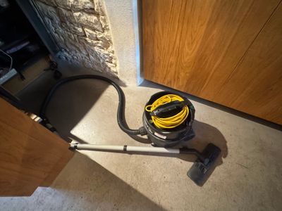 un aspirateur posé sur le sol à côté d'une porte