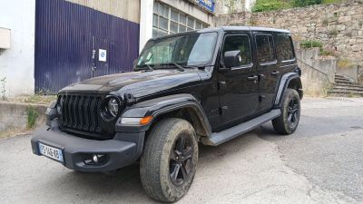 une jeep noire garée devant un immeuble