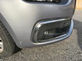 un gros plan du pare-chocs avant d'une voiture sur lequel est posé un chat