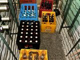 bottles of beer are lined up in crates in a cage