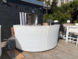a large white tub sitting on top of a wooden deck