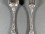 pair of silver plated spoons and a fork on a gray surface