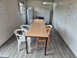 une table et des chaises dans une pièce équipée d'un réfrigérateur
