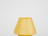 the yellow lamp is sitting on a white surface with a black cord
