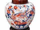 un grand vase orné d'un oiseau, posé sur un socle