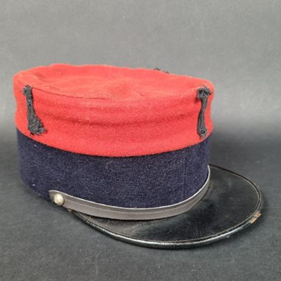 une image représentant un chapeau rouge et bleu posé sur une table noire