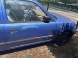 une petite voiture bleue garée sur le bord de la route