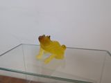 une table en verre sur laquelle se trouve une figurine de grenouille jaune