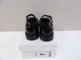 pair of black leather shoes with buckles on top of a white box