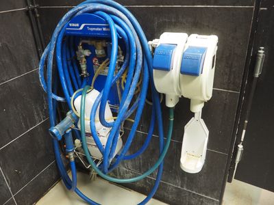 un tuyau bleu raccordé à des toilettes blanches dans une salle de bains