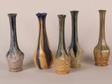 five different colored vases lined up in a row