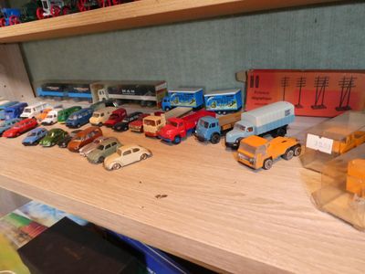 many toy cars and trucks on a shelf in a room