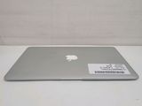 a silver apple laptop sitting on a white table
