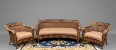 three wicker chairs and a couch on a rug