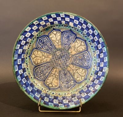 a blue and green plate with a decorative design on it