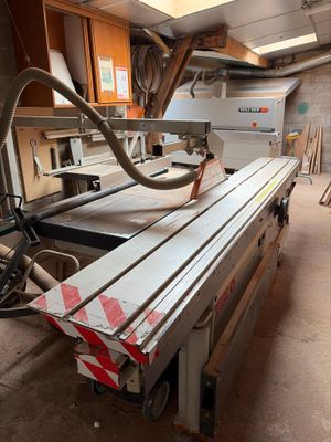 a machine that is cutting a piece of wood in a room