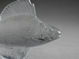 a glass figurine of a fish on a stand