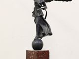 statue d'un ange tenant un oiseau, posée sur un socle en marbre