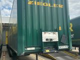 un grand camion-benne vert garé sur un parking