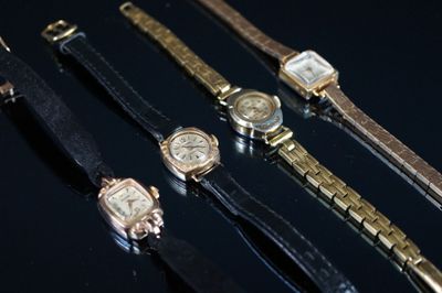 Plusieurs montres sont alignées les unes à côté des autres sur une surface noire