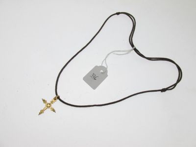 un collier à cordon noir orné d'une croix en or