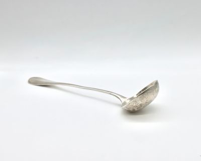 silver spoon on a white surface with a small spoon sticking out of it