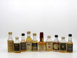 bottles of different types of alcohol lined up on a white surface