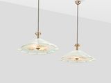 a pair of glass pendant lights hanging from a ceiling