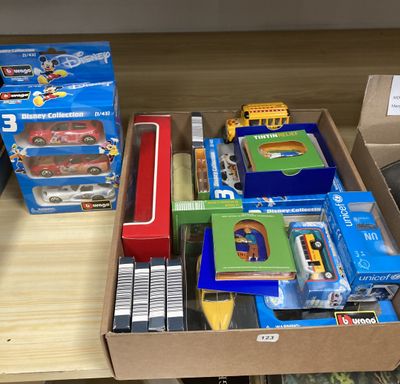 une boîte remplie de jouets posée sur une table, à côté d'une autre boîte contenant d'autres jouets