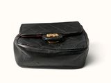 a black purse that is sitting on a white surface