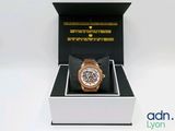 une boîte avec une montre à l'intérieur sur une surface blanche