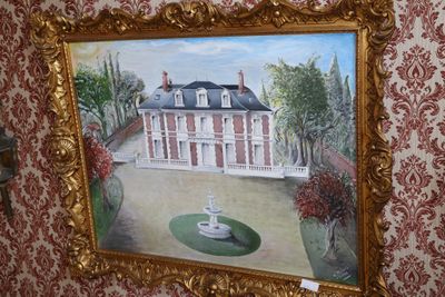 une photo d'un tableau représentant une maison accroché au mur