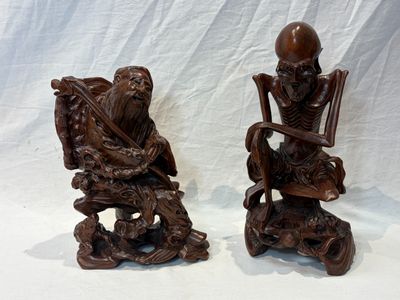 paire de figurines en bois sculpté représentant un homme et une femme assis sur une chaise
