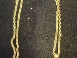 a close up of a gold necklace with a cross on it